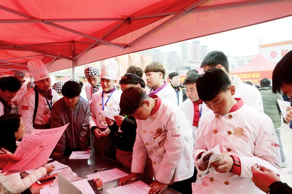 学生在招聘会现场投递简历